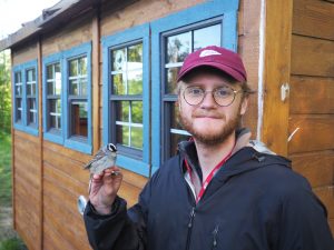 Quinn holding a White-crowned Sparrow at Iona Island Bird Observatory